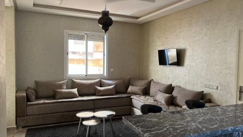 a living room with a couch and a tv at Tiwaline Tarsime App C in Sidi Ifni