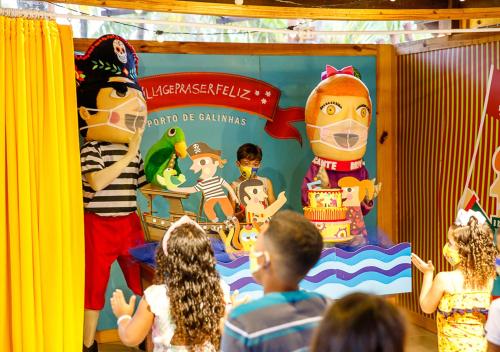 a group of children looking at a clown display in a room at Hotel Village Porto De Galinhas in Porto De Galinhas