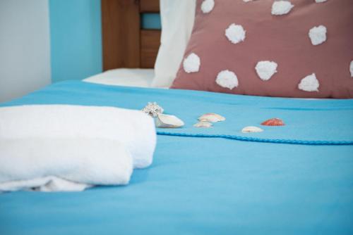 a blue bed with white towels and pillows on it at Daisy's room in Archangelos