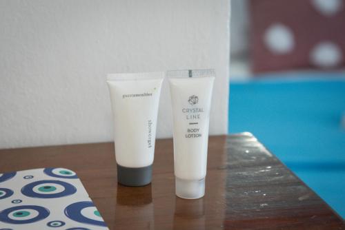 two bottles of cream like products sitting on a table at Daisy's room in Archangelos