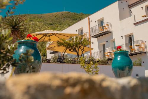 três vasos azuis sentados em frente a um edifício em Villa Totò Resort em Cefalù