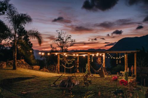 a backyard wedding with a swing and lights at sunset at Chalé Refugio da Pedra SP in São Bento do Sapucaí