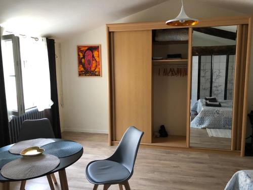 Cette chambre comprend une table, des chaises et un miroir. dans l'établissement La Pignotte, à Avignon