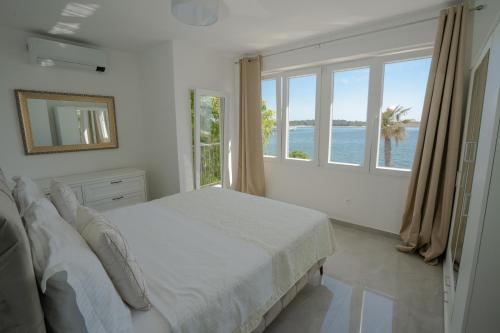 a bedroom with a bed with a view of the ocean at Villa Lucini Dvori in Novalja
