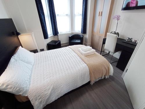 a bedroom with a large white bed and a desk at The Little Studio- Self contained one bed studio flat in Oxford