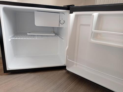 an empty refrigerator with its door open in a kitchen at The Little Studio- Self contained one bed studio flat in Oxford