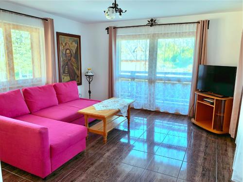 uma sala de estar com um sofá rosa e uma mesa em Domek Maria Mąka em Zakopane