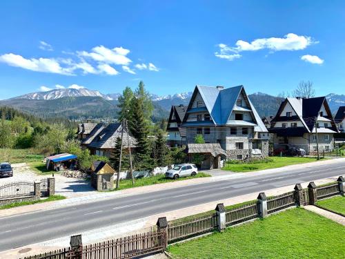 a house on the side of a road with mountains at Domek Maria Mąka in Zakopane
