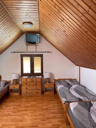 Schlafzimmer im Dachgeschoss mit 2 Betten und einem TV in der Unterkunft Sklípek U píchlé galusky in Strachotín