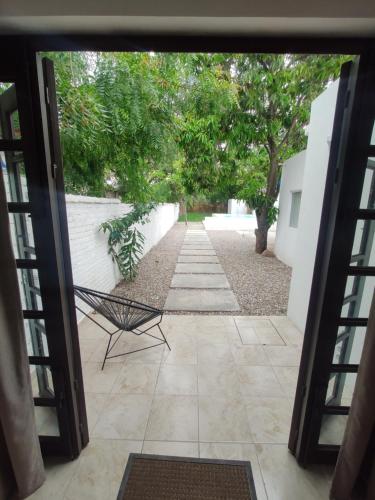 a door leading into a courtyard with a chair at Casa Mango amplia con alberca y cerca de la Media Luna !!! in Río Verde