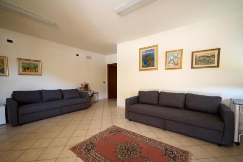 a living room with two couches and a rug at Albergo Shine in Acqualagna