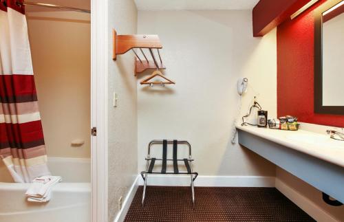 a bathroom with a sink and a toilet and a stool at Red Roof Inn Santa Ana in Santa Ana