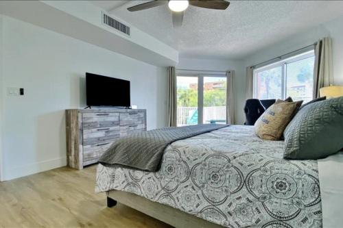 a bedroom with a bed and a flat screen tv at Beach Cottage 1104 in Clearwater Beach