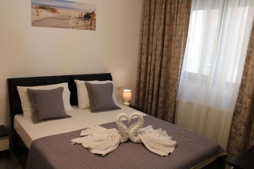 a bedroom with a bed with two towels on it at Bluewaves Apartment Mamaia Nord in Mamaia Nord