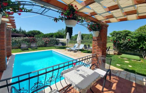 a swimming pool in a yard with a table and a patio at Luxury VILLA LE ROSE in Poreč