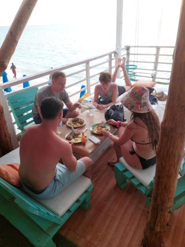 un grupo de personas sentadas alrededor de una mesa en un barco en posada donde Uriel Playa tranquila, en Barú