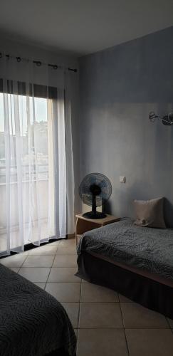sypialnia z dwoma łóżkami i dużym oknem w obiekcie Très bel appartement,proche plage et centre ville. w Calvi