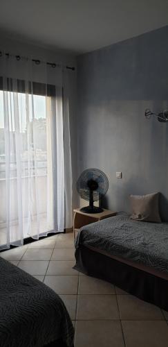 a bedroom with two beds and a large window at Très bel appartement,proche plage et centre ville. in Calvi