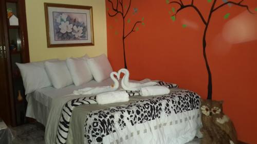 1 dormitorio con 1 cama con un árbol pintado en la pared en Chacara Santa Barbara, en Manaus