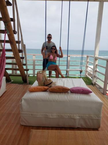 a man and a woman sitting on a swing at posada donde Uriel Playa tranquila in Baru