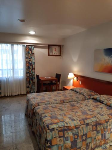 リオデジャネイロにあるオセアノ コパカバーナ オテルのベッドとテーブルが備わるホテルルームです。