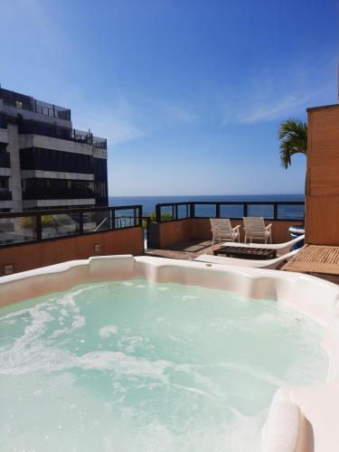 a hot tub with the ocean in the background at Oceano Copacabana Hotel in Rio de Janeiro