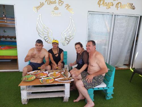 a group of people sitting around a table with food at posada donde Uriel Playa tranquila in Baru