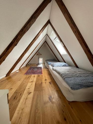 a attic room with a bed and a wooden floor at Historische Unterkunft in Lorch in Lorch