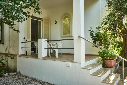 una veranda di una casa con tavolo e sedie di Gli ulivi -Appartamento al centro a Cala Gonone
