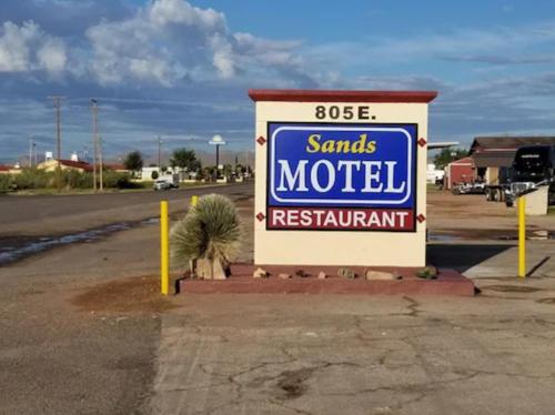 una señal para un motel de Santa Rolls en un estacionamiento en Sands Motel, en Van Horn
