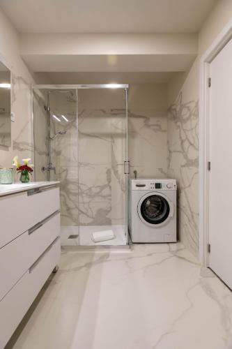 a white bathroom with a washing machine in a shower at Green Apartment Pedras Salgadas in Pedras Salgadas