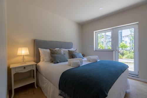 ein Schlafzimmer mit einem großen Bett mit einer blauen Decke in der Unterkunft Green Apartment Pedras Salgadas in Pedras Salgadas