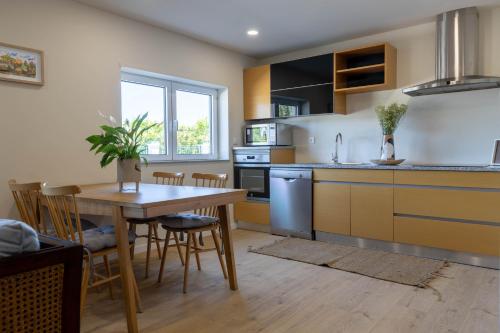 a kitchen with a table and a dining room at Green Apartment Pedras Salgadas in Pedras Salgadas
