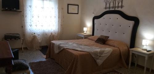 a bedroom with a large bed with two lamps on it at La cascina della grotta di tufo in San Valentino