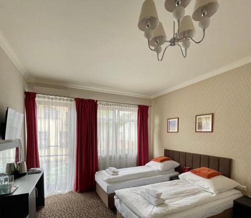 a hotel room with two beds and a chandelier at Apartamenty Centrum in Olkusz