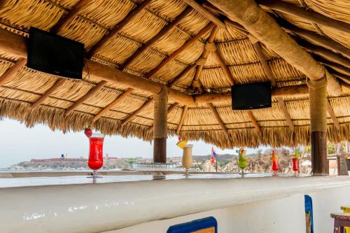 a bar with a straw roof with a view of the ocean at Camino Real Zaashila Huatulco in Santa Cruz Huatulco
