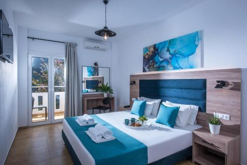 ヘルソニソスにあるFloral Hotelのベッドルーム1室(青と白のベッド、タオル付)