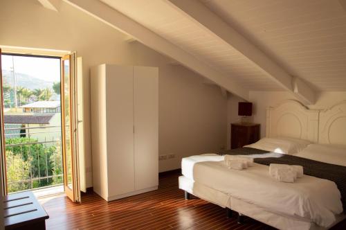 1 Schlafzimmer mit 2 Betten und einem großen Fenster in der Unterkunft Skylight Sorrento in Sant'Agnello