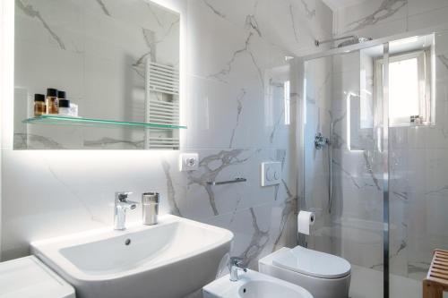 een witte badkamer met een wastafel en een douche bij The bell tower apartment - Bellagio center in Bellagio