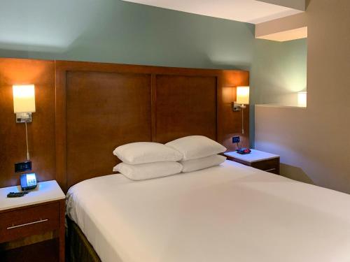 a bedroom with a large white bed with two pillows at MainStay Suites Orange County John Wayne Airport in Santa Ana