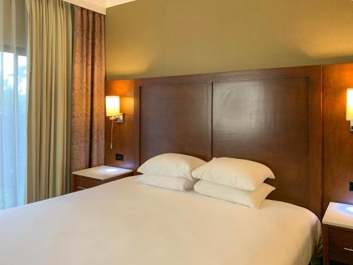 a bedroom with a large white bed with two pillows at MainStay Suites Orange County John Wayne Airport in Santa Ana