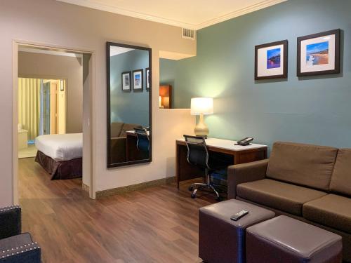 a hotel room with a couch and a bed and a desk at MainStay Suites Orange County John Wayne Airport in Santa Ana