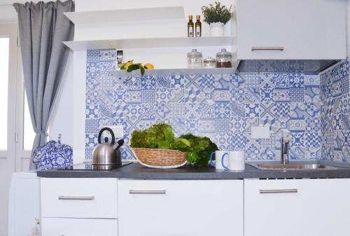 a kitchen with blue and white tiles on the wall at Luna Chiara Home in Sant'Agnello