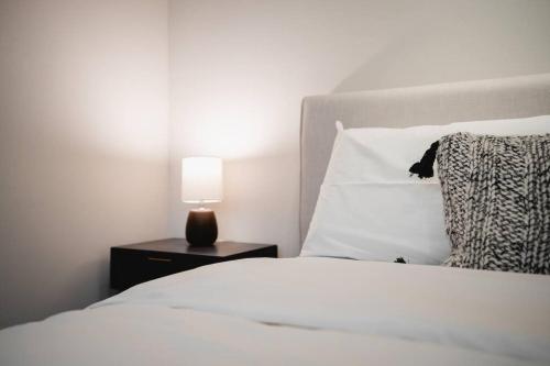 a bedroom with a white bed with a lamp on a night stand at The San Diego Studio - Free Parking in San Diego