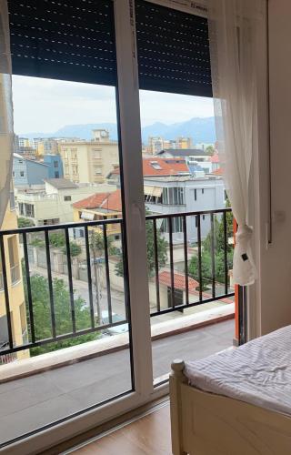 Schlafzimmer mit einem großen Fenster mit Stadtblick in der Unterkunft The beautiful view in Tirana