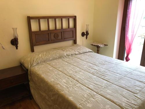 1 dormitorio con 1 cama grande y cabecero de madera en Borgo Villa, en Acceglio