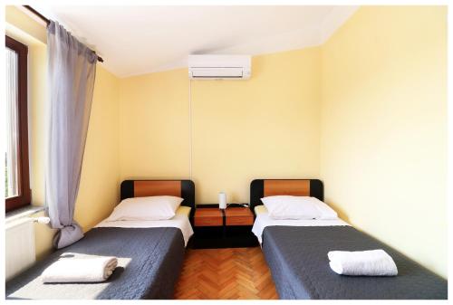 two twin beds in a room with a window at Kuća za odmor Angelina in Primošten
