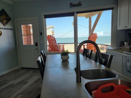 a kitchen with a sink and a view of the ocean at Las Casitas on Magnolia Beach - Casita A in Port Lavaca
