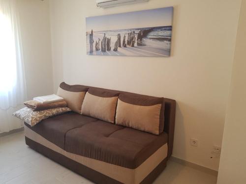 a couch in a living room with a painting on the wall at Family apartment Krivokapic in Baošići