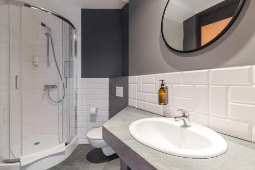 a bathroom with a sink and a shower and a toilet at Villa Verdi Pleasure & Spa in Łeba
